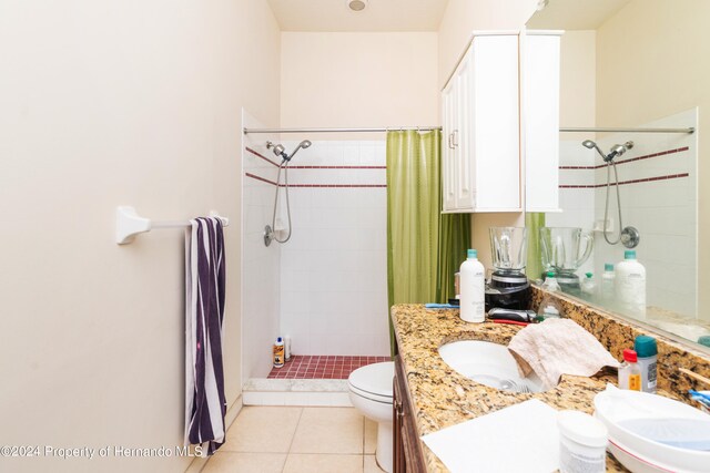 bathroom featuring vanity, curtained shower, tile patterned flooring, and toilet