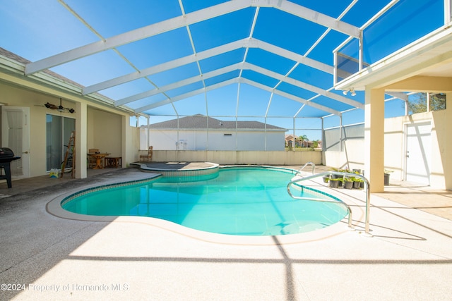 view of swimming pool featuring a patio, a lanai, and an in ground hot tub