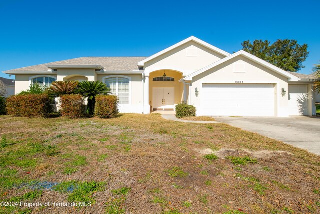 ranch-style house with a front lawn and a garage