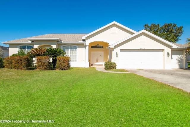 ranch-style home featuring a garage and a front lawn