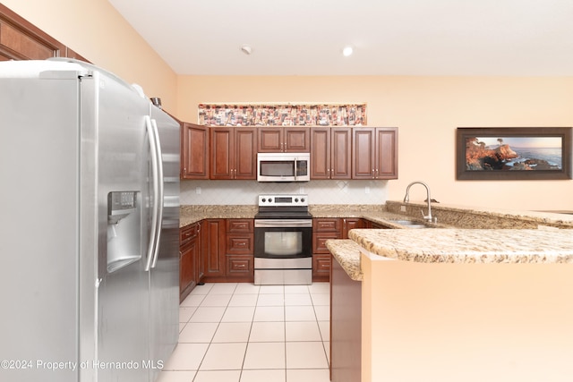 kitchen featuring stainless steel appliances, sink, light stone counters, kitchen peninsula, and tasteful backsplash