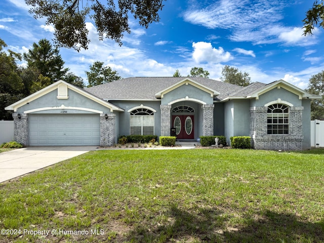 ranch-style home featuring a front lawn and a garage