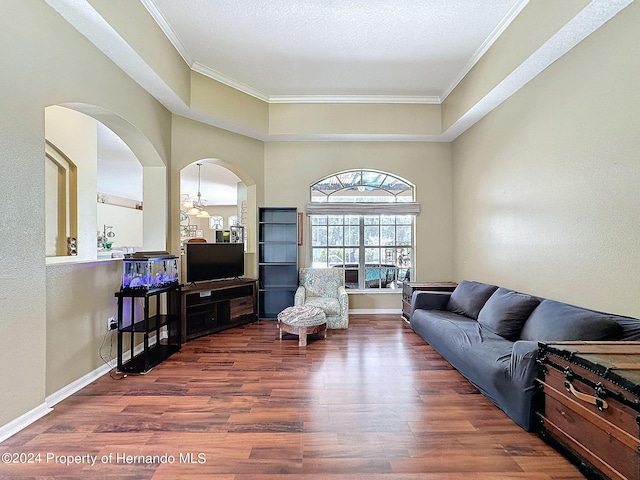 living room with dark wood-type flooring and crown molding