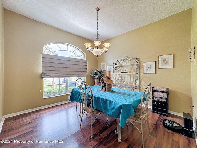 dining space featuring hardwood / wood-style floors, a notable chandelier, a healthy amount of sunlight, and a textured ceiling