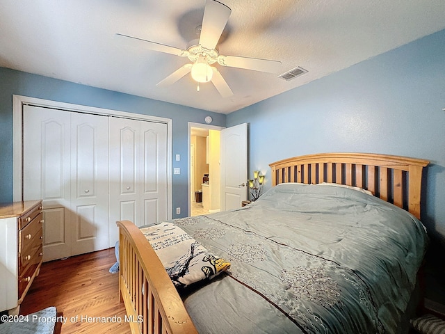 bedroom featuring light wood-type flooring, ceiling fan, and a closet