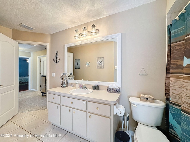 bathroom with vanity, tile patterned flooring, a textured ceiling, and toilet