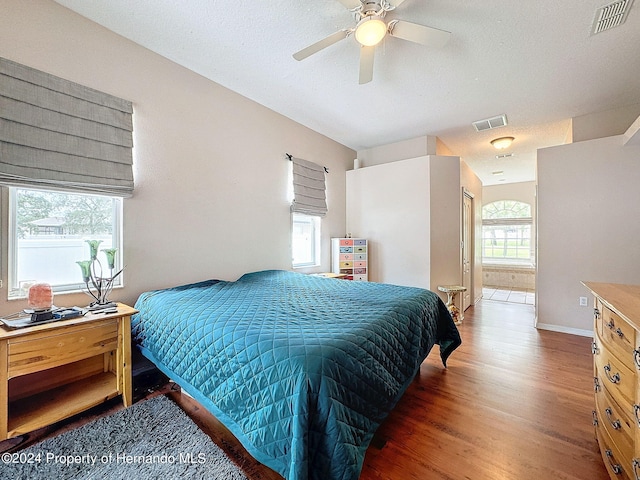 bedroom featuring a textured ceiling, dark hardwood / wood-style floors, and ceiling fan