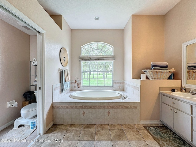 bathroom featuring vanity, tiled bath, tile patterned floors, and toilet