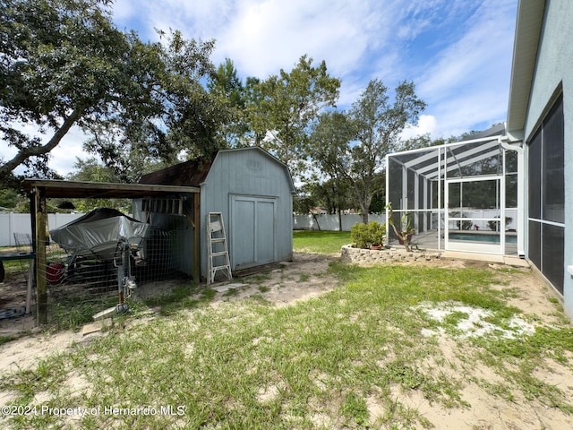 view of yard featuring glass enclosure, a storage unit, and a fenced in pool