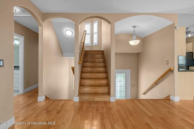 stairway with hardwood / wood-style flooring and ceiling fan