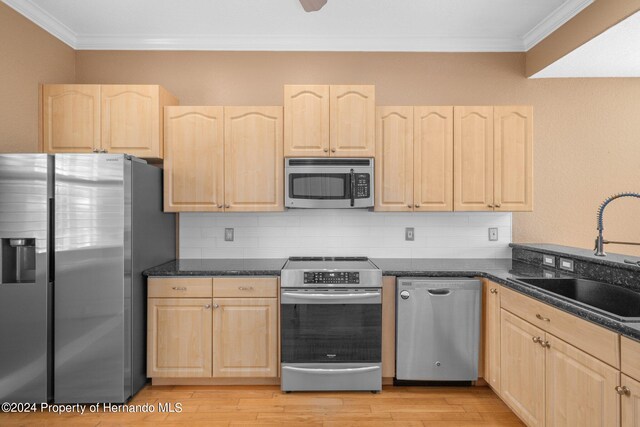 kitchen with light brown cabinetry, sink, light wood-type flooring, and appliances with stainless steel finishes