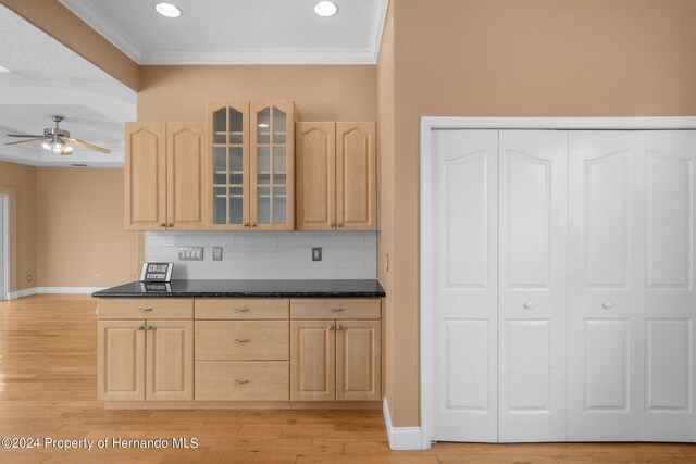 kitchen featuring light wood-type flooring, light brown cabinets, backsplash, and ornamental molding