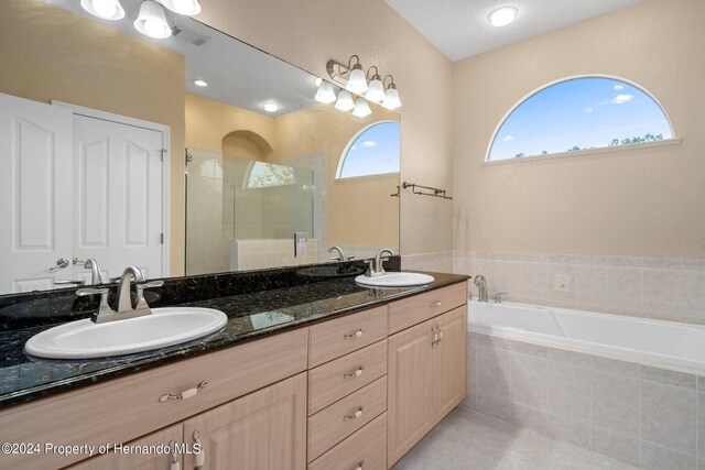 bathroom featuring vanity, plus walk in shower, and tile patterned flooring