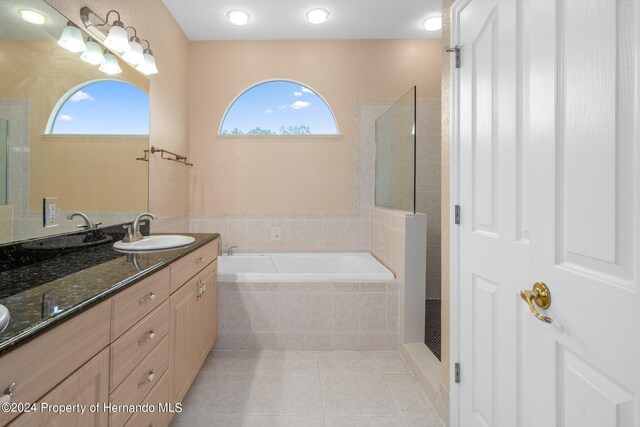 bathroom with tile patterned flooring, vanity, a textured ceiling, and independent shower and bath