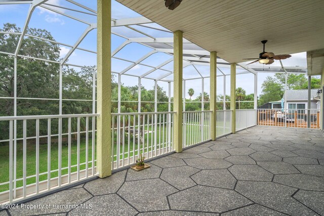 unfurnished sunroom with ceiling fan