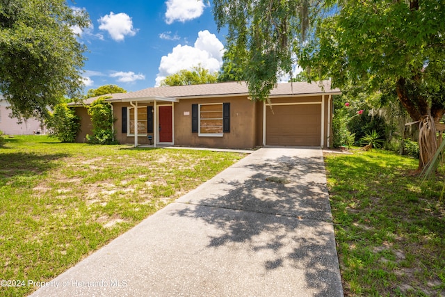 ranch-style home with a garage and a front lawn