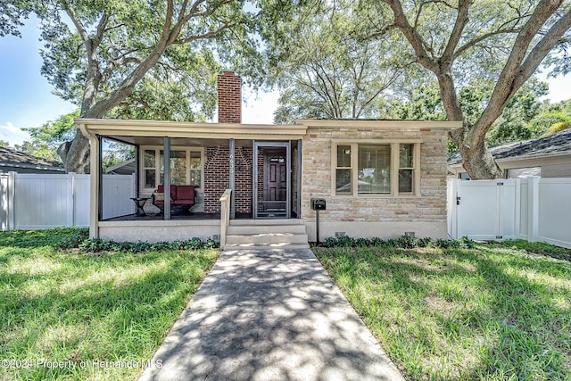 6635 Stewart Ave N, Saint Petersburg, FL 33702 - ranch-style house with a porch, a chimney, and stone siding