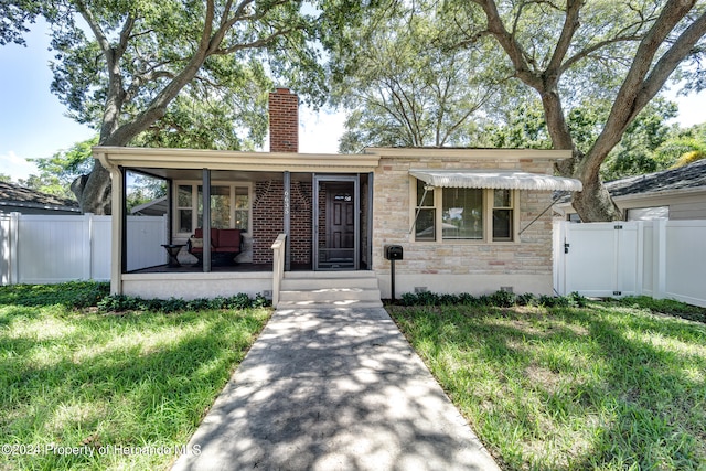 view of front of home with a front yard and covered porch