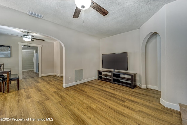 6635 Stewart Ave N, Saint Petersburg, FL 33702 - living room with a ceiling fan, arched walkways, a textured ceiling, and wood finished floors