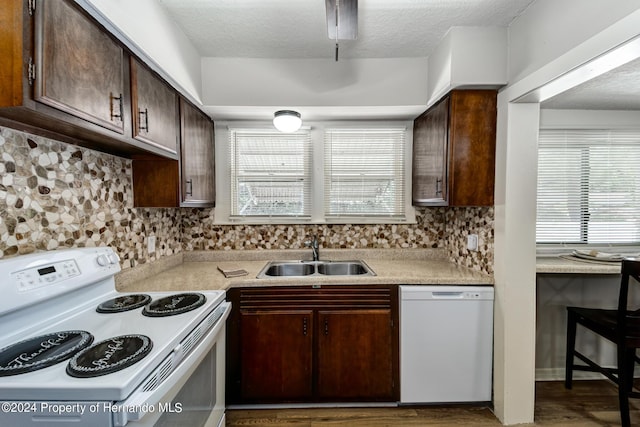 6635 Stewart Ave N, Saint Petersburg, FL 33702 - kitchen with white appliances, a sink, backsplash, light countertops, and a textured ceiling