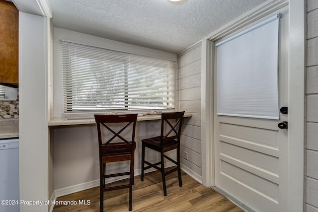 dining area featuring light hardwood / wood-style flooring and a textured ceiling