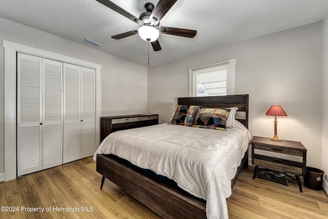 bedroom with a closet, light wood-type flooring, and ceiling fan