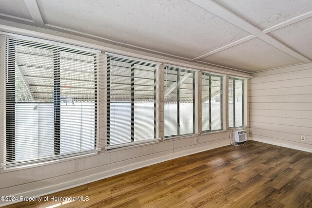 unfurnished sunroom with an AC wall unit