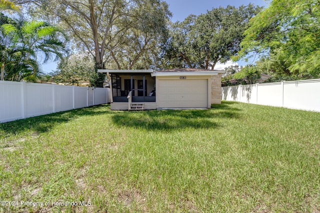 rear view of house featuring a sunroom and a yard