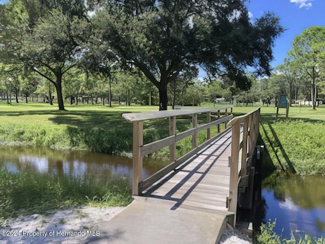 6635 Stewart Ave N, Saint Petersburg, FL 33702 - dock featuring a lawn, a water view, and view of wooded area