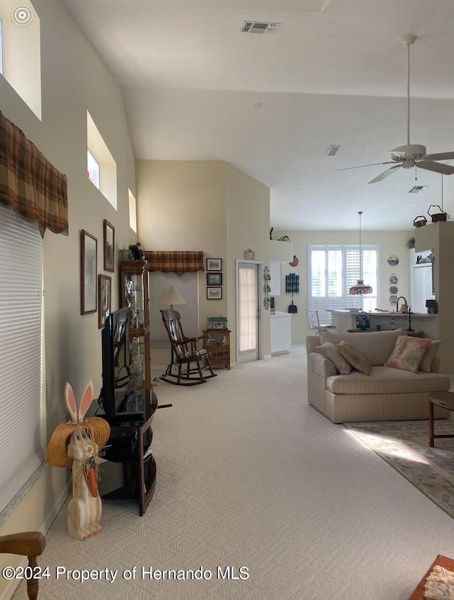 living room featuring lofted ceiling, ceiling fan, and carpet floors