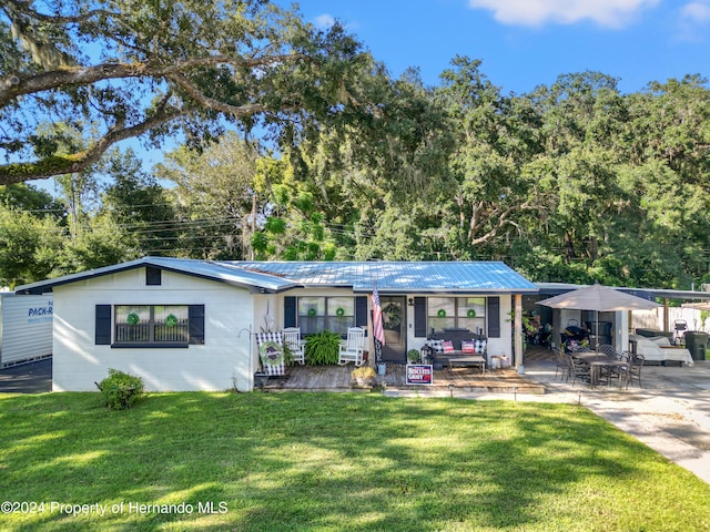 view of front of home featuring a porch, a front lawn, and a patio area