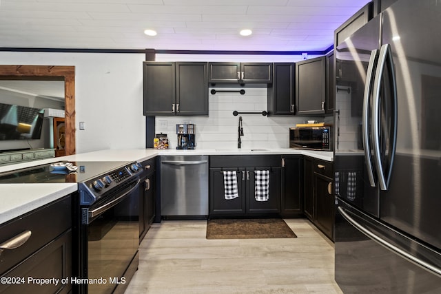 kitchen featuring light hardwood / wood-style floors, sink, tasteful backsplash, crown molding, and appliances with stainless steel finishes