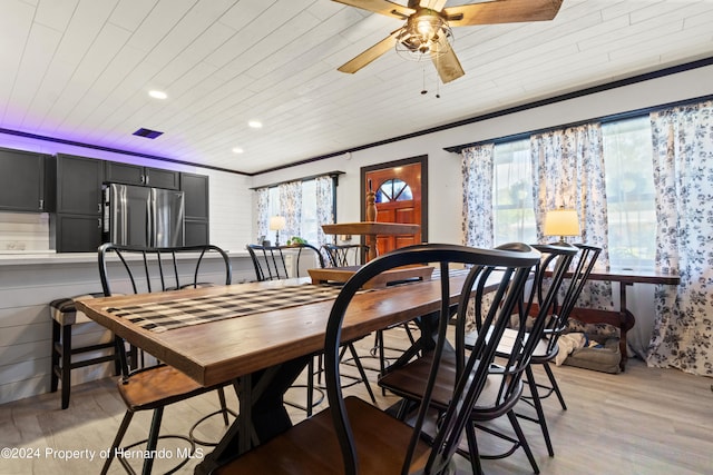 dining space with ceiling fan, plenty of natural light, light wood-type flooring, and ornamental molding