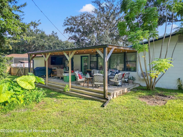 rear view of house featuring outdoor lounge area, a lawn, and a wooden deck