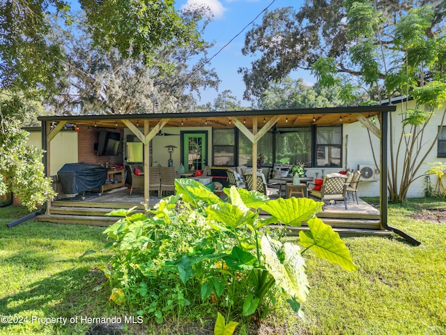 back of house with outdoor lounge area, a yard, and a wooden deck