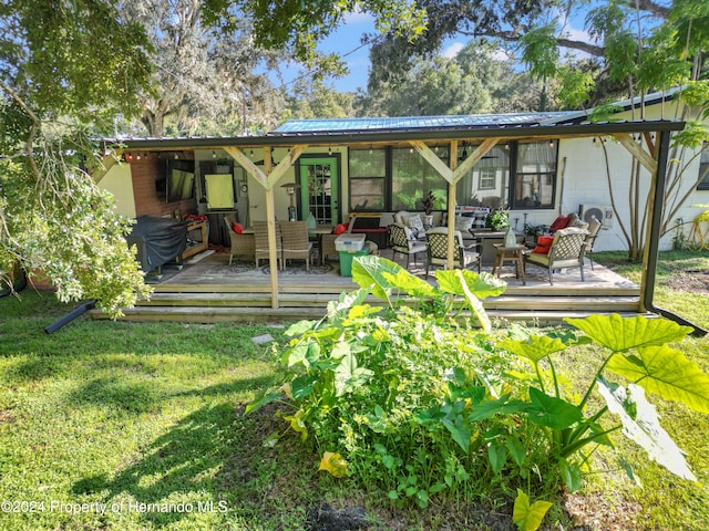 rear view of house with an outdoor living space, a yard, and a deck