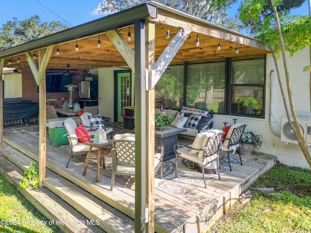 wooden deck with ac unit and an outdoor living space