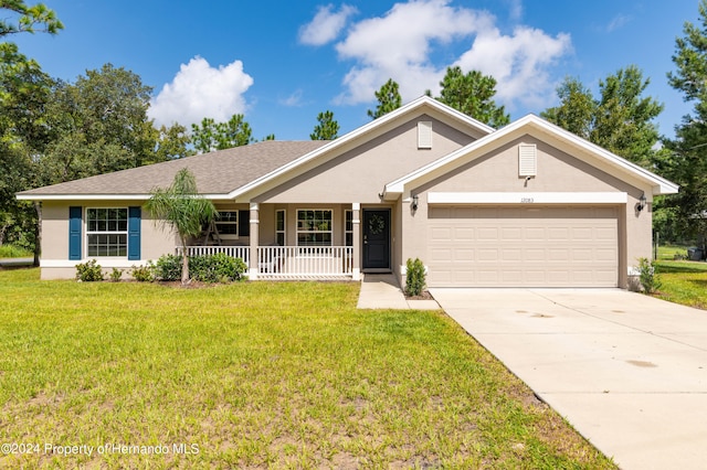 ranch-style house featuring a front lawn, a garage, and covered porch