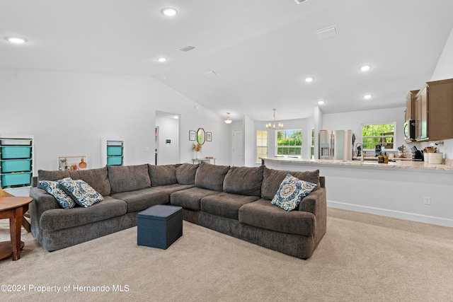 living room featuring light colored carpet, sink, lofted ceiling, and a notable chandelier