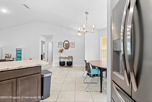 kitchen with decorative light fixtures, stainless steel fridge with ice dispenser, light tile patterned floors, an inviting chandelier, and vaulted ceiling