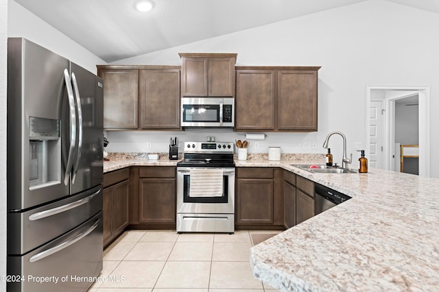 kitchen with sink, vaulted ceiling, light tile patterned flooring, and stainless steel appliances