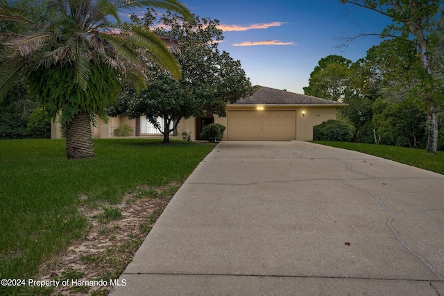 view of front of property with a garage and a yard