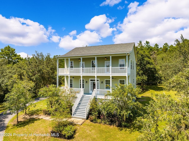 view of front of house featuring a front lawn, ceiling fan, and covered porch