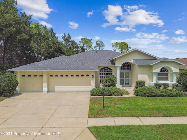 single story home featuring a front lawn and a garage