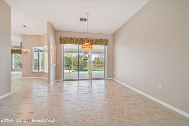 unfurnished dining area featuring light tile patterned flooring and vaulted ceiling