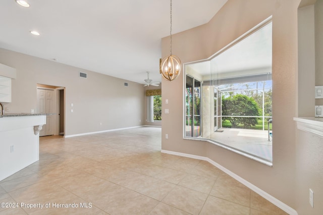 unfurnished dining area with a wealth of natural light, ceiling fan, and light tile patterned floors