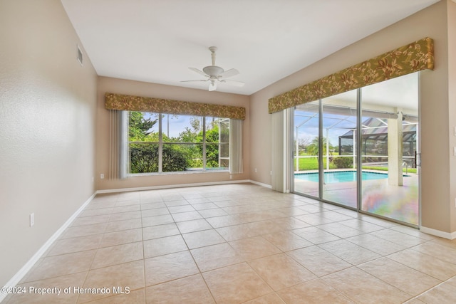 tiled empty room featuring ceiling fan