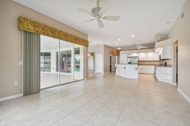 unfurnished living room featuring light tile patterned floors and ceiling fan