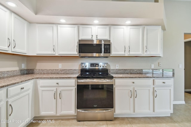 kitchen featuring white cabinetry, stainless steel appliances, and light tile patterned floors