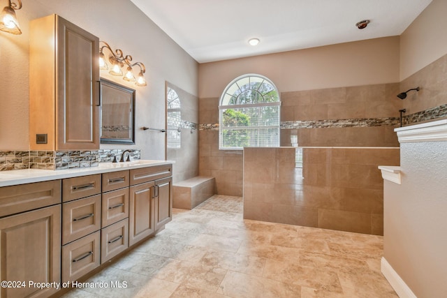 bathroom featuring vanity, a tile shower, and tasteful backsplash